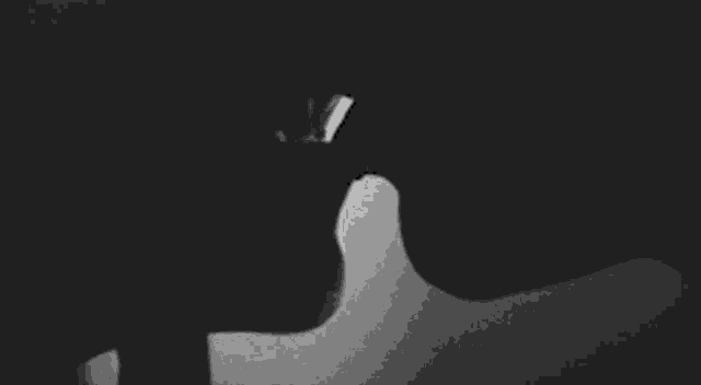 a black and white photo of a man and woman kissing .