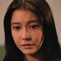 a woman with long dark hair looks at the camera