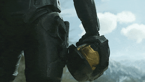 a man in a black suit holds a yellow helmet in his hand