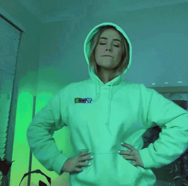 a woman wearing a white hoodie with a rainbow logo on it
