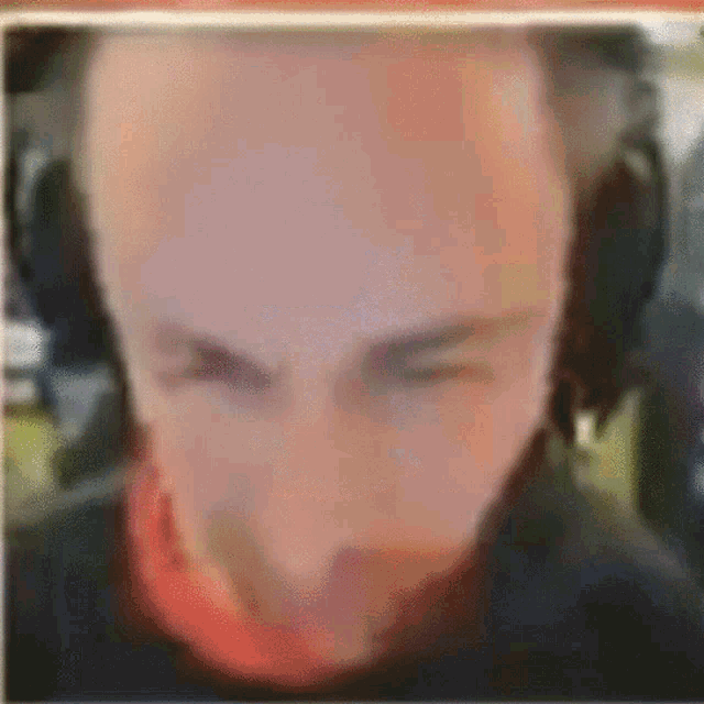 a blurry picture of a man wearing headphones and a red scarf around his neck .