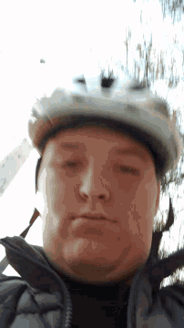 a man wearing a white helmet is looking down at something