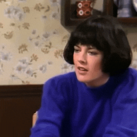 a woman in a blue sweater is sitting at a table .