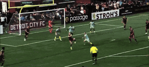a soccer game is being played in front of an astroh 's sign