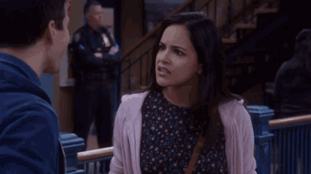 a woman in a pink cardigan looks at a man