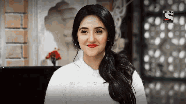 a woman wearing a white sweater and red lipstick is on a sony television ad