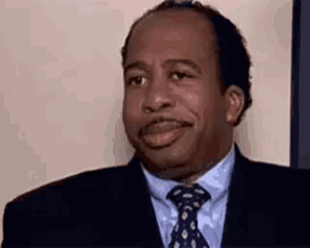 a man in a suit and tie is smiling at the camera .