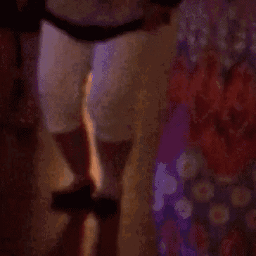 a woman in a floral dress is dancing with a man in white shorts