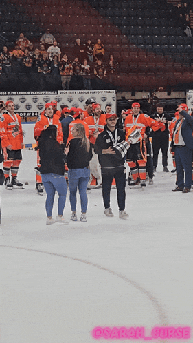 a group of hockey players on the ice with a sign that says playoff finals