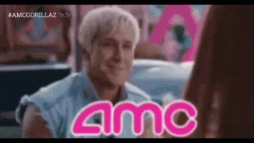 a man in a denim vest is smiling in front of a sign that says amc on it
