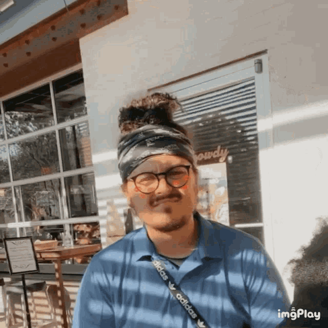 a man wearing glasses and a bandana with the word adidas on the strap