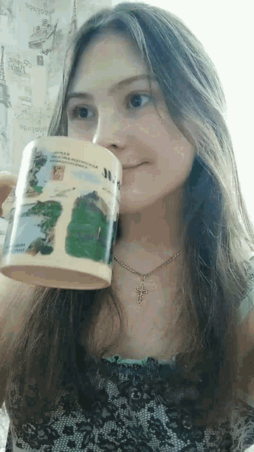 a woman is drinking from a mug that says " russia " on it