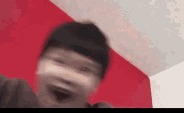 a blurry picture of a person making a funny face .