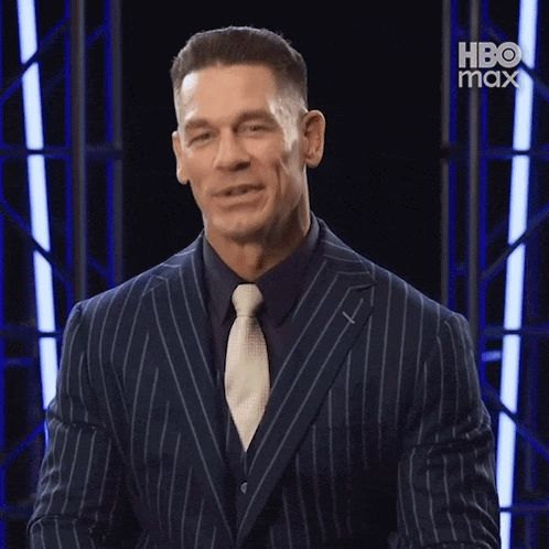 a man in a suit and tie is smiling and saying enjoy .