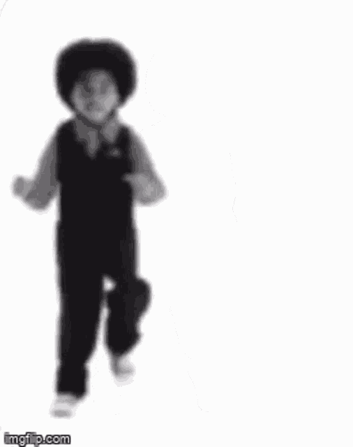 a young boy is dancing in a black and white photo with his arm outstretched .