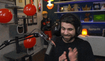 a man wearing headphones stands in front of a microphone in a room with sypherpk on the wall