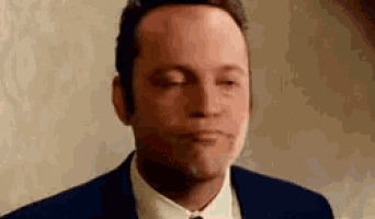a close up of a man in a suit and tie making a funny face .