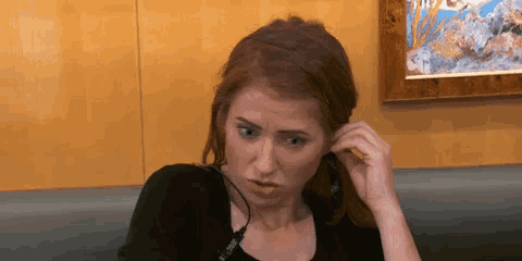 a woman wearing a headset is sitting on a couch and making a funny face