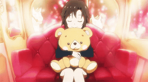 a girl is sitting on a red couch hugging a teddy bear .