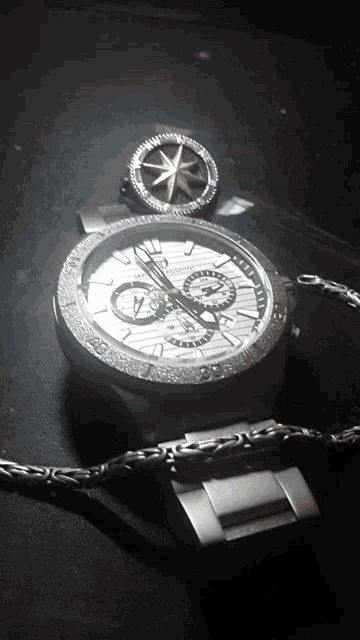 a watch with a compass on top of it and a bracelet