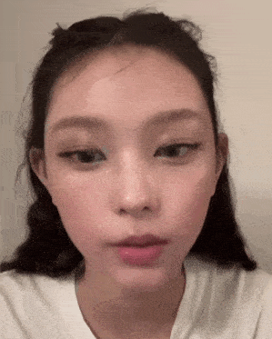a close up of a woman 's face with a white shirt