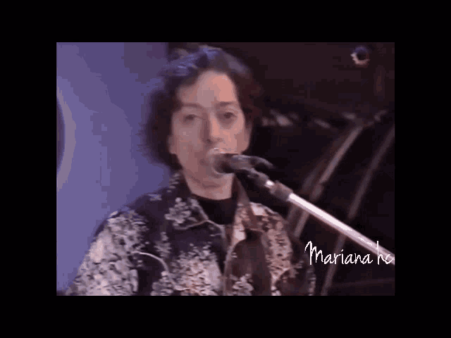 a woman singing into a microphone with the name mariana on the bottom left