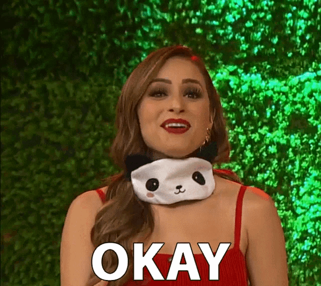 a woman is wearing a panda mask around her neck and says okay