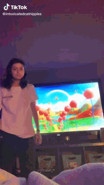 a woman is standing in front of a tv screen with a tiktok watermark