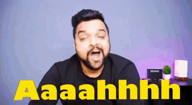 a man with a beard is making a funny face in front of a sign that says aaahhh