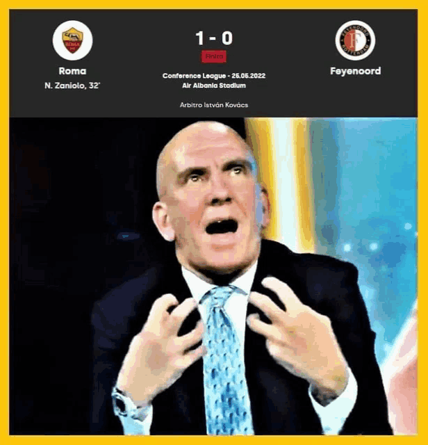 a man in a suit and tie is making a funny face while watching a soccer game