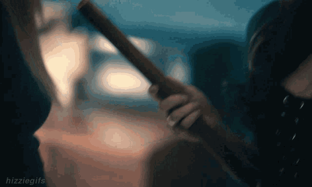 a woman is holding a wooden stick in her right hand .