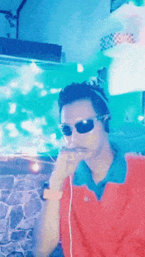 a man wearing sunglasses and headphones is smoking a cigarette in front of a fish tank