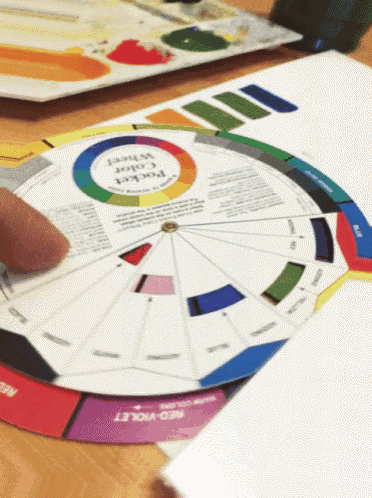 a person is using a color wheel that says red violet on the bottom