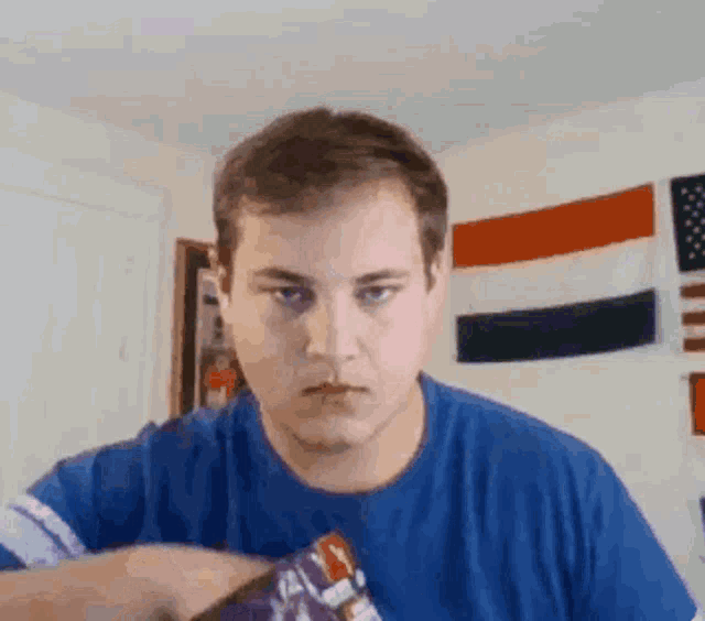 a man in a blue shirt holds a purple object in his hand