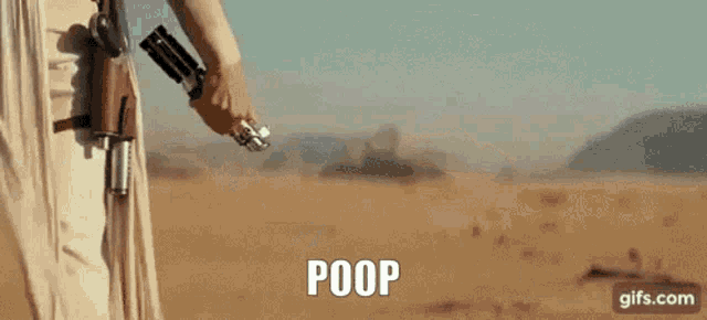a woman in a white dress is walking in the desert with the words `` boobs '' written on the screen .