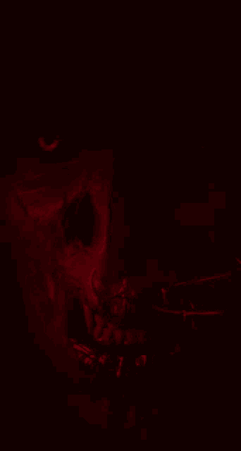a close up of a skull with red eyes and teeth