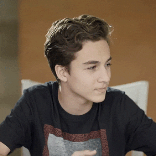 a young man wearing a black t-shirt with a graphic on it