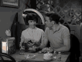 a man and a woman are sitting at a table in a restaurant .