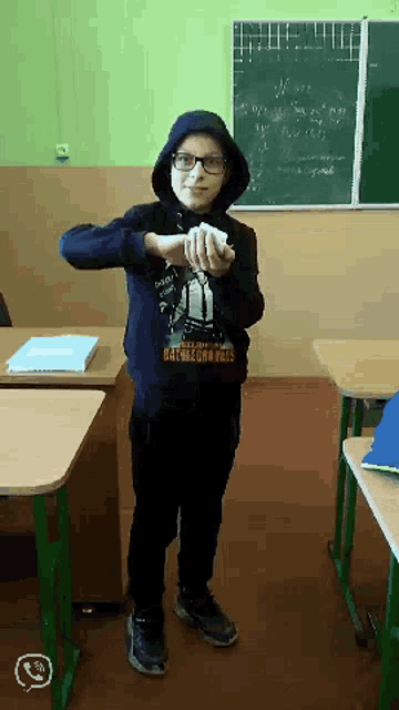 a boy in a classroom wearing a hoodie that says battlegrounds