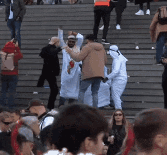 a group of people are standing on a set of stairs and dancing .
