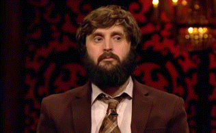 a man with a beard is wearing a brown suit and tie .