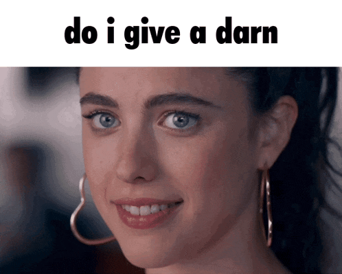 a woman wearing hoop earrings is smiling with the words do i give a darn below her