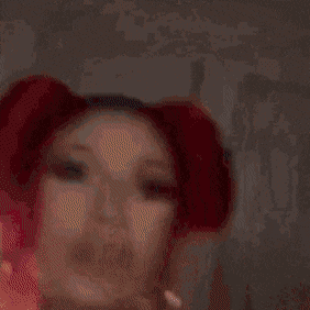 a close up of a woman with red hair and pigtails .