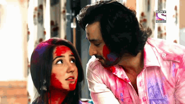 a man and a woman are covered in colored powder and the word sony is on the bottom left