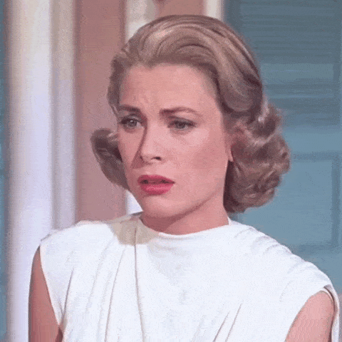 a close up of a woman wearing a white dress making a funny face .
