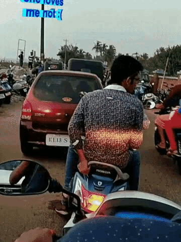 a man riding a honda scooter in a busy street