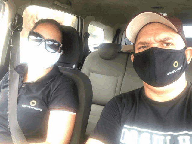 a man and a woman in a car wearing face masks that say grupoincode