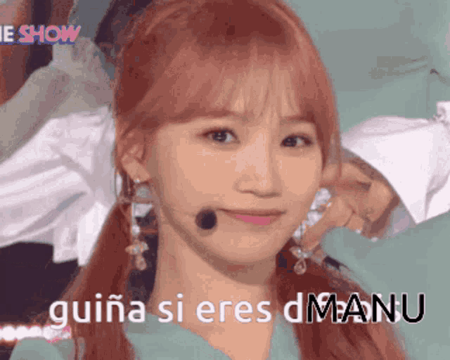 a girl with red hair is wearing a green shirt and earrings and says guiana si eres manu
