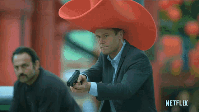 a man wearing a red cowboy hat is holding a gun in a netflix ad