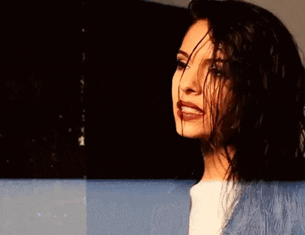 a woman with wet hair is standing in front of a wall .